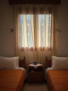 a bedroom with two beds and a window at Λευκή Καμέλια in Anilio Pelion