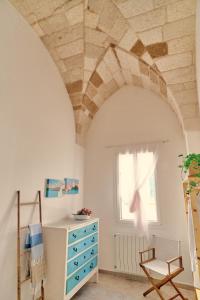 a room with a blue dresser and a window at Itaca in Castro di Lecce