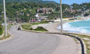 eine kurvenreiche Straße neben einem Strand mit Häusern in der Unterkunft Areito Vintage in Enriquillo