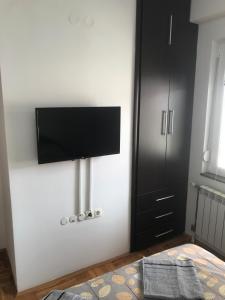 a bedroom with a flat screen tv on a wall at Guest House Sani in Skopje