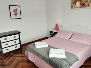a bedroom with a bed and a dresser with two towels at Villa Rica House in Negreira