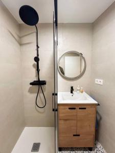 La salle de bains est pourvue d'une douche, d'un lavabo et d'un miroir. dans l'établissement Acogedor y moderno apartamento, à Zamudio