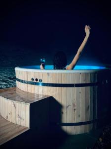 una persona in una vasca idromassaggio nell'acqua di notte di Bies-Czaderskie Chaty a Ustrzyki Dolne