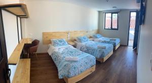a room with three beds and a table and a desk at The Cranky Croc Hostel in Bogotá