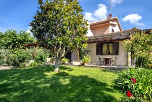 a small house with a tree in the yard at Agriturismo La Sassicaia in Castiglione della Pescaia