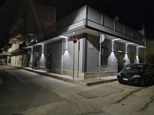 un coche aparcado delante de un edificio por la noche en La Casa di Ray e Anto, en Cassibile