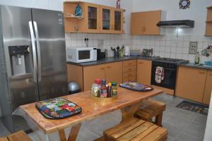 a kitchen with a wooden table and a refrigerator at Wanjara's Nest in Windhoek