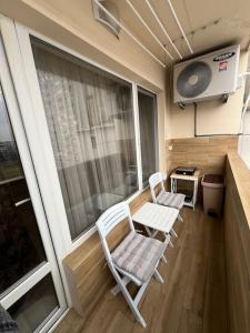 einen kleinen Balkon mit 2 Stühlen und einem TV in der Unterkunft Tei-Zi apartments in Burgas City