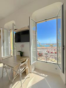 a dining room with a table and a large window at MENTON # MONACO - F1 GP - 4 PERSONS - SEA VIEW - NEW - PARKING - CLIM - PREMIUM - BEACH and SUN in Menton