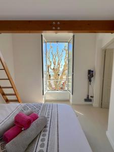 a bedroom with a bed with pink pillows and a window at MENTON # MONACO - F1 GP - 4 PERSONS - SEA VIEW - NEW - PARKING - CLIM - PREMIUM - BEACH and SUN in Menton