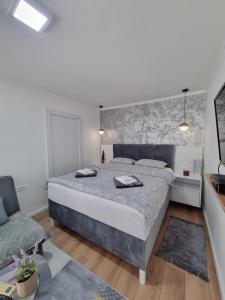 una camera con un grande letto e un divano di Apartments Deni a Mostar