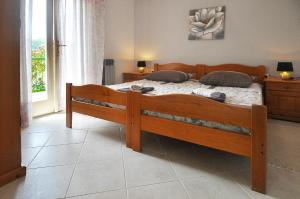 um quarto com uma cama de madeira e uma janela em Ferienwohnung für 4 Personen ca 45 qm in Rabac, Istrien Bucht von Rabac em Rabac