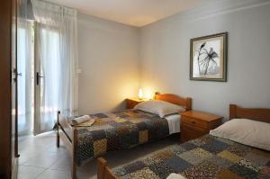 um quarto com 2 camas e uma janela em Ferienwohnung für 4 Personen ca 45 qm in Rabac, Istrien Bucht von Rabac em Rabac