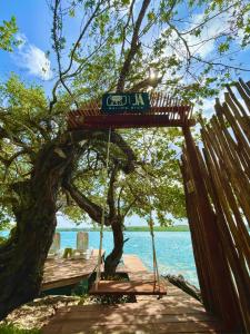 un muelle de madera con un cartel colgando de un árbol en Estancia del Agua Luxury View, en Xul-Ha