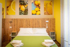 een slaapkamer met een groen bed met foto's aan de muur bij i sapori del levante in La Spezia