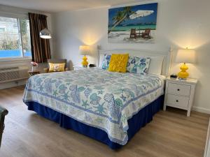 een slaapkamer met een bed met een blauwe en witte sprei bij Mariner Motel in Falmouth