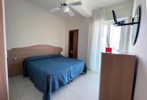 Schlafzimmer mit einem Bett und einem Deckenventilator in der Unterkunft Hotel Majestic in Senigallia