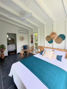 ein Schlafzimmer mit einem großen Bett in einem Zimmer in der Unterkunft Kaz et Palmiers in Saint-François