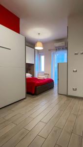a bedroom with a red bed and a room with a table at Il Palazzetto in Gaeta
