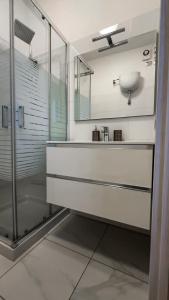 ein Bad mit einer Glasdusche und einem Waschbecken in der Unterkunft Il Palazzetto in Gaeta