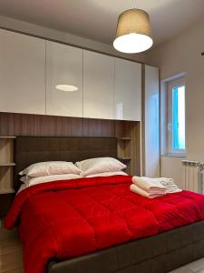 a bedroom with a red bed with a red blanket at Il Palazzetto in Gaeta