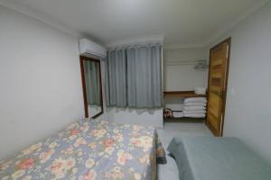 um pequeno quarto com uma cama e uma janela em Apartamento Ponta da Fruta para até 4 pessoas 201 em Vila Velha