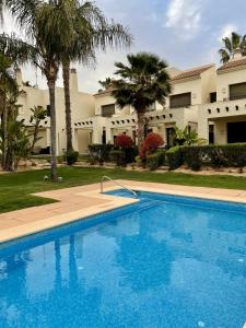 uma grande piscina azul em frente a um edifício em Casa Mila Roda Golf Resort Murcia em Roda