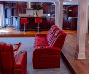 a living room with a red couch and a kitchen at Luxurious Private Basement Suite in Ashton in Silver Spring