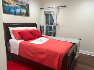 a bedroom with a bed with red pillows and a window at Luxurious Private Basement Suite in Ashton in Silver Spring