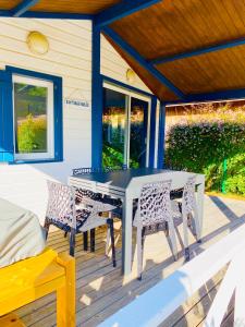 eine Veranda mit einem Tisch und Stühlen darauf in der Unterkunft Cottage 5 personnes Bias Mimizan in Bias