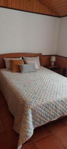 a bedroom with a large bed with pillows at Casa Campo e Praia in Rogil