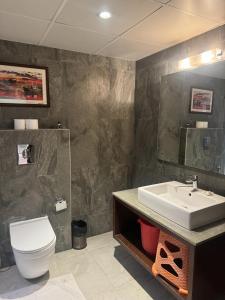 a bathroom with a white toilet and a sink at Hotel Luxury Holiday - Banjara hills prime location in Hyderabad