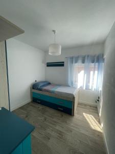 um pequeno quarto com uma cama e uma janela em Doamvid Universidad em Ciudad Real