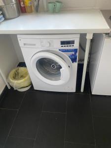 eine Waschmaschine in einer Küche unter einer Theke in der Unterkunft Zimmervermittlung Hemelingen in Bremen