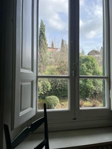 ein offenes Fenster mit Gartenblick in der Unterkunft Albero Mago in Florenz