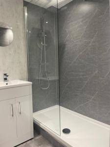 a shower with a glass door in a bathroom at Gateway to the Loch in Balloch