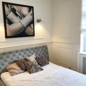 uma cama com almofadas num quarto em Glamour Apartment Sopot em Sopot