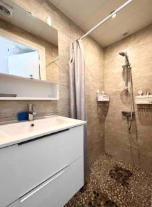 La salle de bains est pourvue d'un lavabo et d'une douche. dans l'établissement L’escale Bleue, à Mimizan