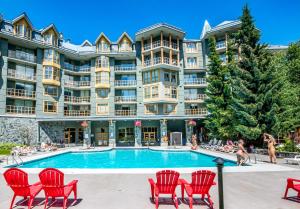 un hotel con piscina e sedie rosse di Cascade Lodge a Whistler