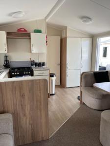 eine Küche und ein Wohnzimmer mit einem Sofa und einem Tisch in der Unterkunft Olivia Ann in Caernarfon