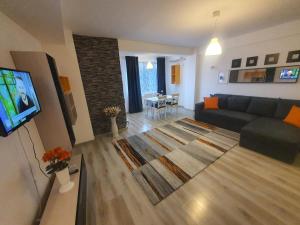 un salon avec un canapé et une télévision dans l'établissement Fundeni Apartments, à Bucarest