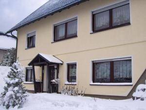 une maison avec de la neige devant elle dans l'établissement Ferienwohnung für 2 Personen ca 55 qm in Frauenwald am Rennsteig, Thüringen Rennsteig, à Ilmenau