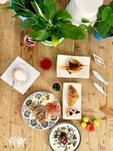 uma mesa com pratos de alimentos e uma planta em Hotel Nizza Creative Hotel em Rimini