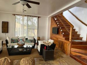 a living room with a couch and a staircase at VILLA FLOREANA in Puerto Velasco Ibarra