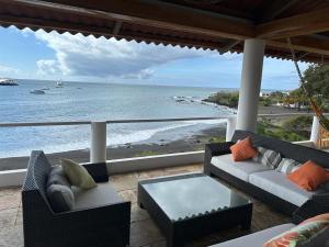 un porche con sofás y vistas al océano en VILLA FLOREANA, en Puerto Velasco Ibarra