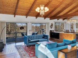 a living room with blue furniture and a wooden ceiling at Stylistic Home and Easy Walk to the Beach in Truro