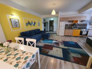 un salon avec un canapé bleu et une cuisine dans l'établissement Fundeni Apartments, à Bucarest