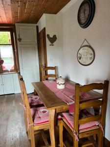 Ray-sur-Saône的住宿－Maison Ray Sur Saône，餐桌和椅子,墙上有鸡