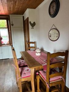 a dining room table and chairs with a chicken on the wall at le Gîte de Marie Ray Sur Saône in Ray-sur-Saône +5 photos