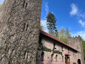 an old stone building with a tree next to it at Le Château du Landsberg in Barr